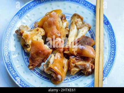 Chinese braised pig trotters in plate with chopsticks aside. Stock Photo