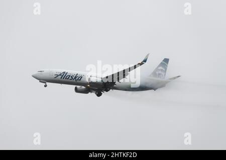 SeaTac, WA, USA - February 28, 2022; Alaska Airlines Boeing 737-900 landing in heavy rain after flight from Tampa to Seattle Tacoma. Stock Photo