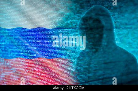 The silhouette of a hacker in front of program code and Russian flag Stock Photo
