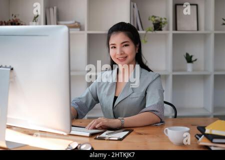 Asian Woman blogger wear blue suit talking with followers, live streaming on social media application. Freelance work from home concept. Stock Photo
