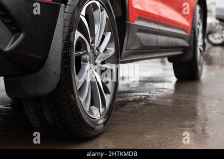 red car with secret bolt in wheel at rainy day, close-up with selective focus Stock Photo
