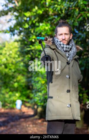 A close of of a discarded shotgun cartridge being being held by a young man that has collected it on a litter pick. Litter pick, rubbish, environmenta Stock Photo