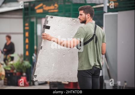 Behind the scene. Filmmaking lighting technician electric engineer adjusting reflector and setup lights diffusion intensity for movie film scene. Ligh Stock Photo