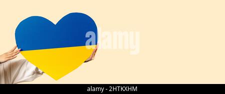 Banner. Cardboard heart the colors of the Ukrainian flag, isolated on the background. A call for peace and an end to the war. No war, stop war. Stock Photo