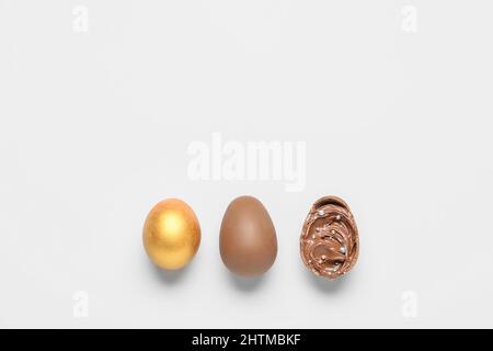 Delicious chocolate eggs with paste filling on light background Stock Photo