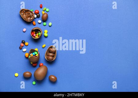 Delicious chocolate eggs with different fillings on blue background Stock Photo