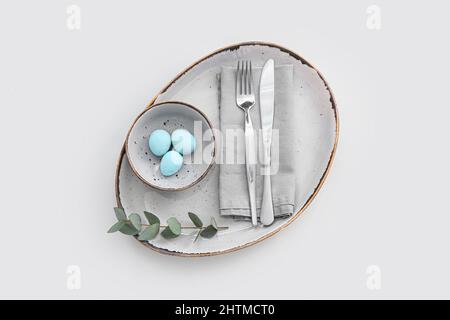 Table setting with Easter eggs and eucalyptus branch on white background Stock Photo
