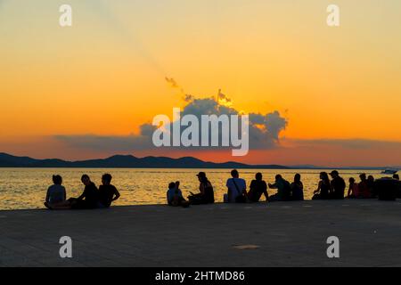 ZADAR, CROATIA - SEPTEMBER 14, 2016: These are the silhouettes of people on the city's embankment at sunset. Stock Photo