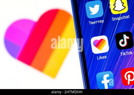 The icon of the Likee short video sharing service application among other applications on smartphone screen. On backgrou Stock Photo