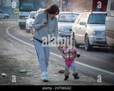 Yavoriv, Ukraine. 26th Feb, 2022. A woman seen with her daughter as they wait in line with their car to cross the border into Poland.At dawn of 24 February 2022, Russia launched a full-scale invasion to Ukraine. Civilian homes and hospitals have been destroyed by the Russian military action which caused many people to become homeless. (Credit Image: © Jana Cavojska/SOPA Images via ZUMA Press Wire) Stock Photo