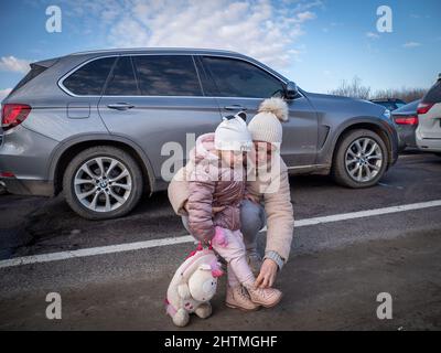 Yavoriv, Ukraine. 26th Feb, 2022. A woman seen with her daughter as they wait in line with their car to cross the border into Poland.At dawn of 24 February 2022, Russia launched a full-scale invasion to Ukraine. Civilian homes and hospitals have been destroyed by the Russian military action which caused many people to become homeless. (Credit Image: © Jana Cavojska/SOPA Images via ZUMA Press Wire) Stock Photo