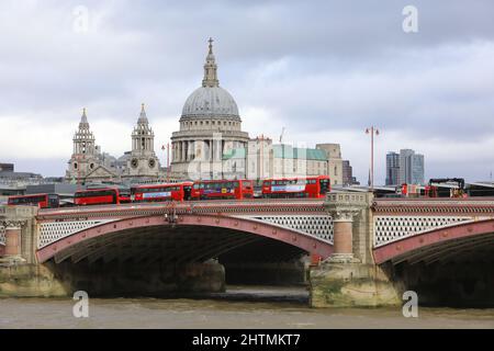 Line of red buses crossing Blackfriars Bridge with St Pauls Cathedral beyond, in London, UK Stock Photo