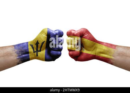 Two hands punch to each others on white background. Country flags painted fists, conflict crisis concept between barbados and spain Stock Photo