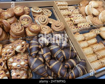 Freshly baked sweet frozen puff shortcrust pastry with jam and cream cheese in bakery. Chocolate croissants, pudding and cinnamon rolls in grocery store. Fresh dessert or afternoon snack Stock Photo