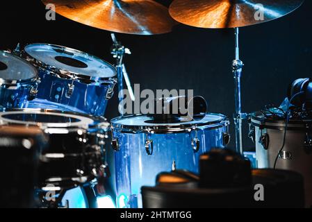 Selective focus shot of illuminated drum instruments on a stage at ...