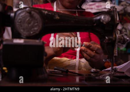 Close-up of the hands of a working seamstress. African seamstress inside her tailor shop Stock Photo