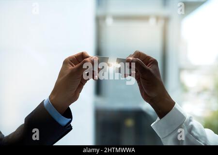 Putting it all together. Closeup shot of two unidentifiable businesspeople holding puzzle pieces together. Stock Photo