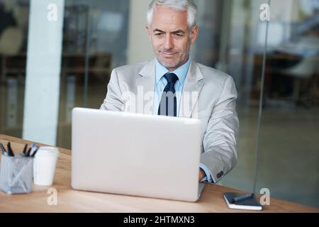 Getting down to business. A manager working on his laptop in the office. Stock Photo