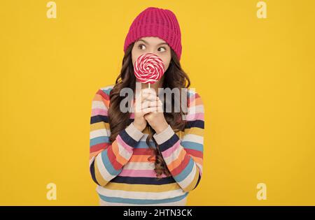 lollipop lady. hipster kid with colorful lollypop sugar candy on stick. caramel candy shop. Stock Photo