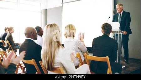 That deserves a round of applause. Cropped shot of a handsome mature businessman giving a speech during an award ceremony. Stock Photo