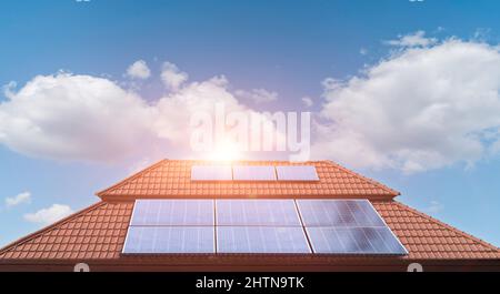 Solar panel on a roof of a house with blue sky cloud background. Photovoltaic, alternative electricity source. sustainable resources Stock Photo