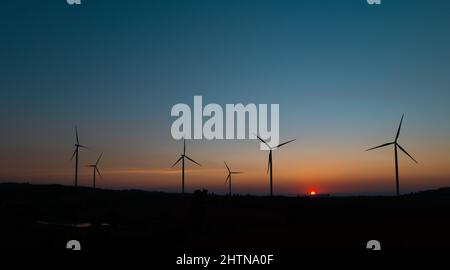 wind turbine field at beautiful sunset sky background. renewable energy Stock Photo