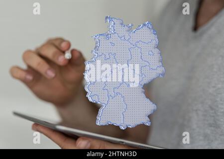 Map of Germany on top of a tablet in the hands of a young man Stock Photo