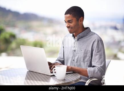 Working outside in the fresh air. Shot of a handsome young man working on his laptop outside. Stock Photo