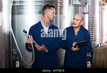 Worker taking notes in fermentation section Stock Photo