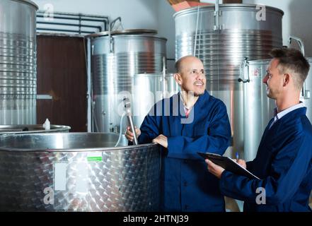 Worker taking notes in fermentation section Stock Photo