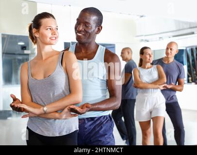 Young smiling people practicing passionate samba in dance class Stock Photo