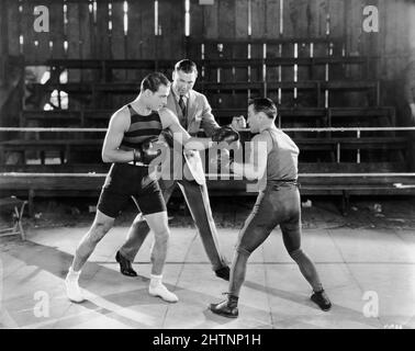 RUDOLPH VALENTINO sparring with professional Boxer ''GENTLEMAN GENE'' DELMONT during a boxing lesson with World Heavyweight Champion JACK DEMPSEY on set candid in1925 at United Studios 5341 Melrose Ave, Los Angeles publicity for Ritz Carlton Pictures, Inc.