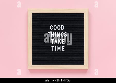 Good things take time. Motivational quote on black letter board on pink background. Concept inspirational quote of the day. Greeting card, postcard To Stock Photo