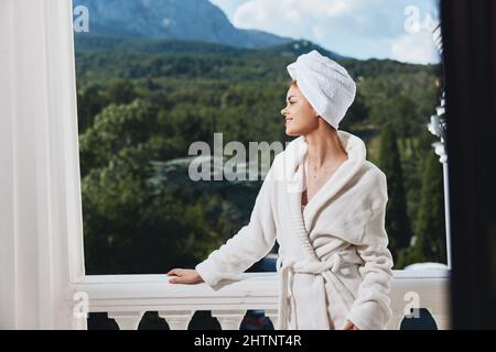 Attractive young woman posing against the backdrop of mountains on the balcony architecture Perfect sunny morning Stock Photo