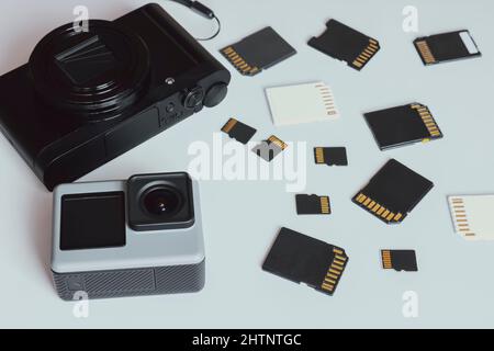 Action camera, digital camera and SD and MicroSD memory cards. Background from gadgets and digital devices. Stock Photo