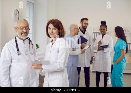 Portrait of two happy, smiling doctors in white coats at work in clinic or hospital Stock Photo