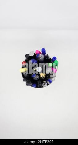 different varieties of gel, ball and colorful pens in a black pen holder isolated in a white background Stock Photo