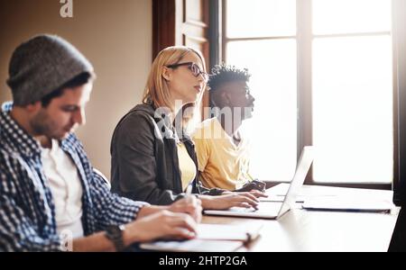 Dedicated to getting educated. Cropped shot of university students in class. Stock Photo