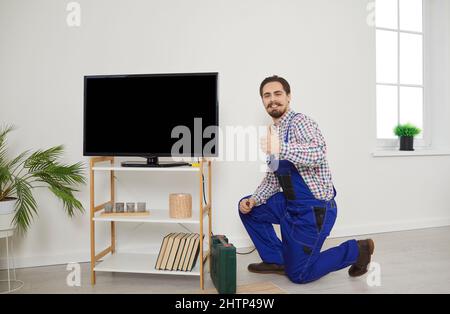 Portrait of professional male technician who repairs, maintains and connects TV. Stock Photo