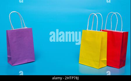 for shopping three colored paper bags on a blue background Stock Photo
