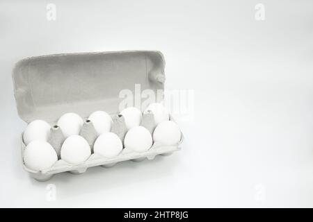 White eggs in an egg carton on a white background. Place for text. copy space Stock Photo