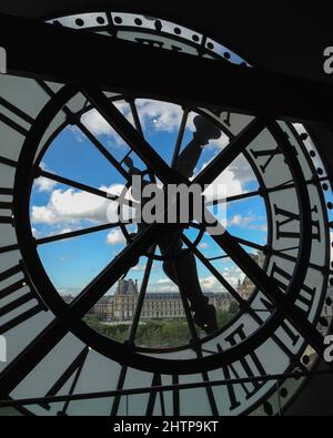 Vertical shot of a view of the Louvre and and a blue sky from a clock on the Musee d'Orsay Stock Photo