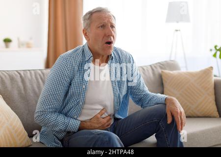 Senior man suffering from stomachache, touching tummy Stock Photo