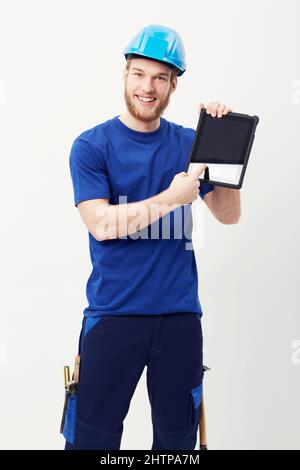 Digital technology makes construction easy. Portrait of a happy young man showing you a digital tablet. Stock Photo
