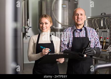 Two brewery workers on beer factory. Stock Photo