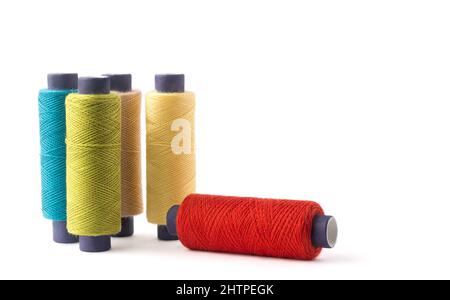 spool of sewing thread used in fabric and textile industry, different colors, isolated on white background Stock Photo