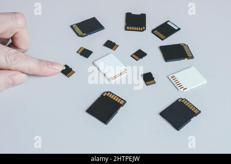 MicroSD memory card and hand on the background of other SD memory cards. Stock Photo
