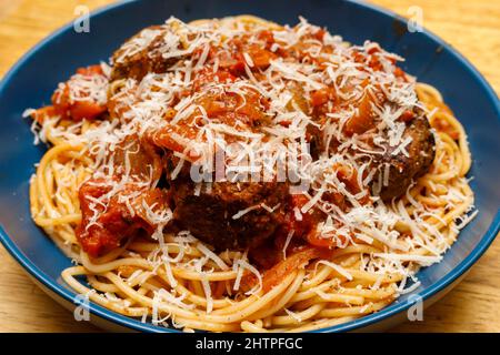 Dish of Beef meatballs and spaghetti with a marinara sauce and parmesan cheese shavings Stock Photo