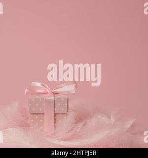 Romantic Easter or Valentine's Day composition on pastel pink background, with feater clouds and polka dot present or gift - minimal arrangement Stock Photo