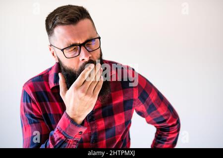 Portrait of man who is tired and yawning. Copy space on image for your text or advert. Stock Photo